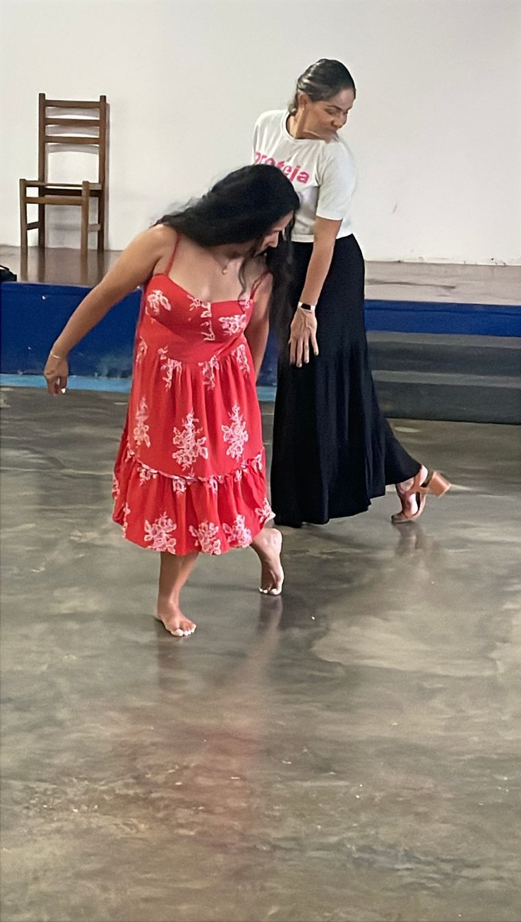 Duas participantes dançando com vestido vermelho